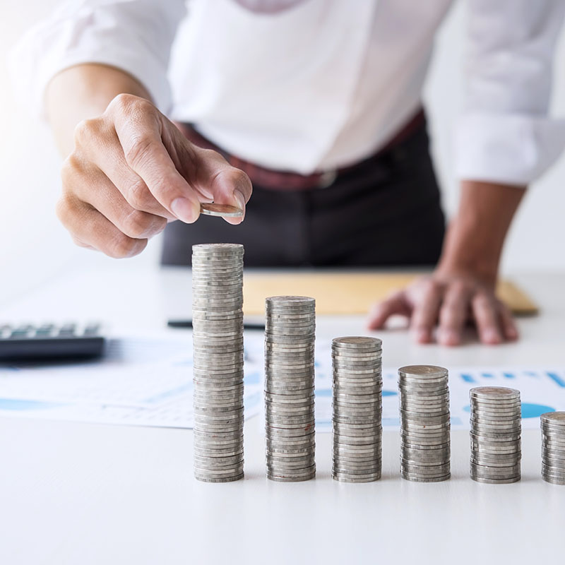 Mężczyzna układający monety w rzędach na biurku